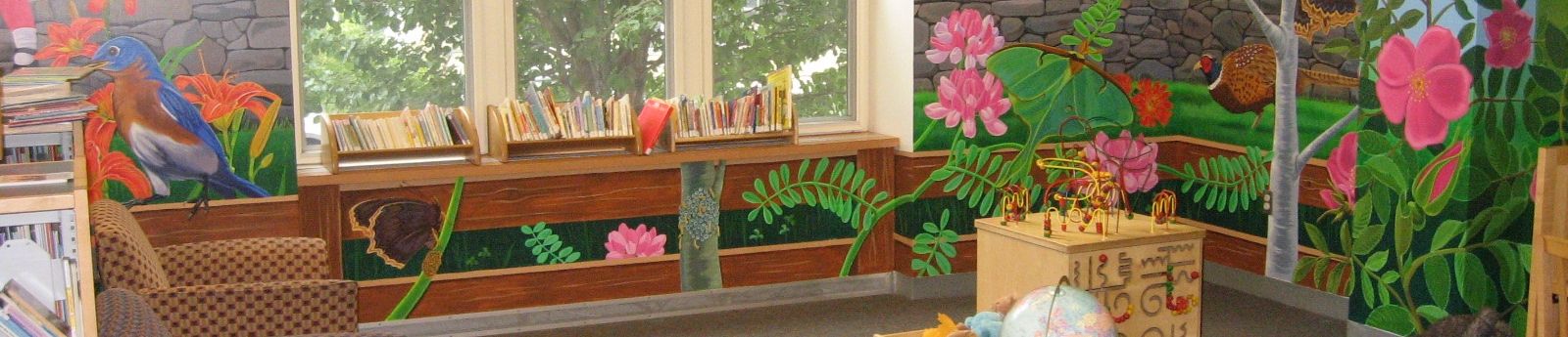 Photo showing a garden mural on the wall of a Children's library room.