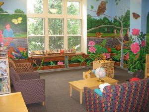 Photo showing a garden mural on the wall of a Children's library room.