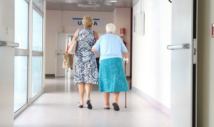 Two women walking down a hospital corridor.